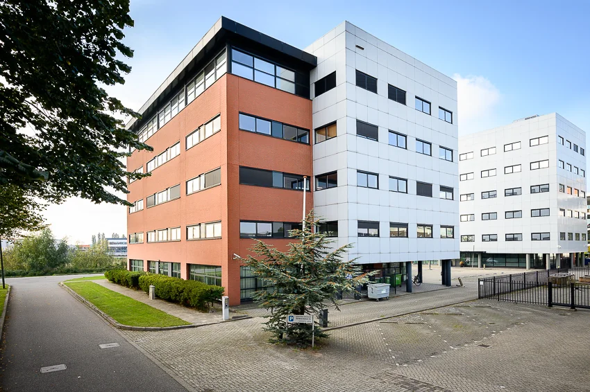 Kantoorgebouwen aan de Karel Doormanweg met rode en witte gevels op een zonnige dag.